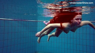 Simonna rossa che mostra il suo corpo sott'acqua