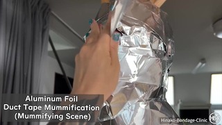 Mumifizierende Szene mit Klebeband aus Aluminiumfolie