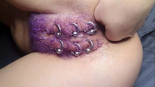 Волосатая пирсингованная киска фиолетового цвета получает анальный фистинг со сквиртом