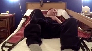 Nurse dresses cripple and uses patient lift to put him in chair