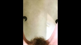 Disabled pixie pees in the tub sitting on a shower chair